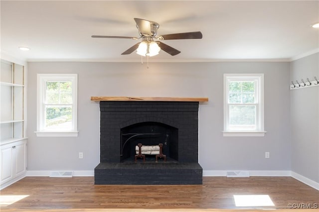 details featuring crown molding, ceiling fan, hardwood / wood-style flooring, and a brick fireplace