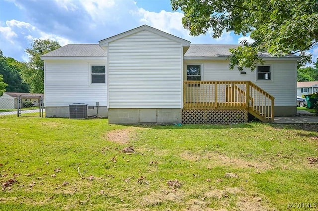 back of property with a deck, central AC unit, and a yard