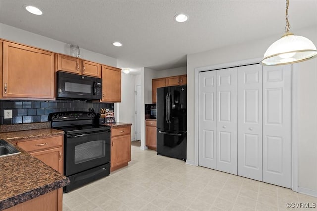 kitchen with decorative backsplash, sink, black appliances, and decorative light fixtures