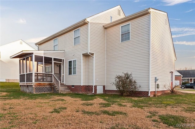 back of house featuring a lawn and a sunroom