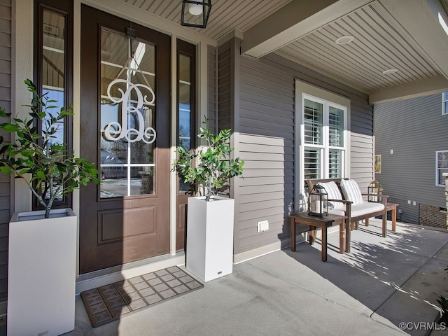 view of exterior entry featuring covered porch