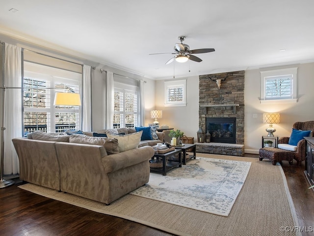 living room featuring ceiling fan, dark hardwood / wood-style flooring, ornamental molding, and a fireplace