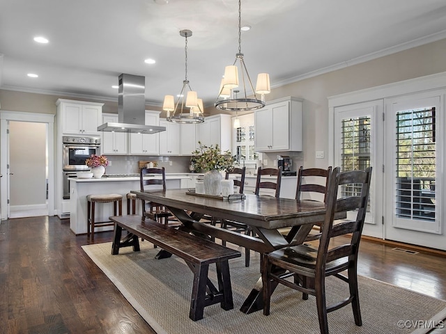 dining room with dark hardwood / wood-style floors, crown molding, and a chandelier