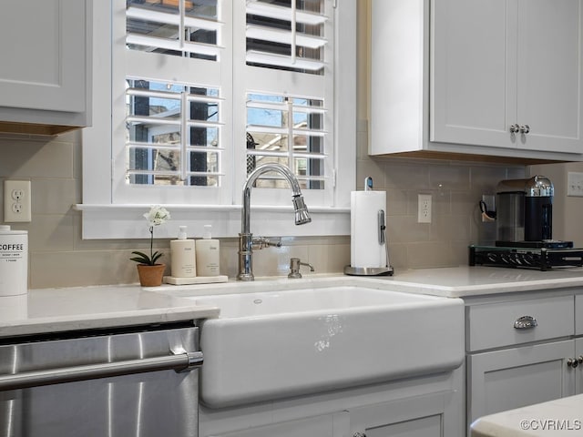 kitchen with sink, white cabinetry, dishwasher, and decorative backsplash