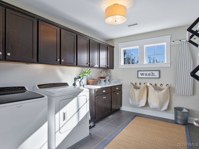 washroom with cabinets, washing machine and dryer, and dark tile patterned flooring