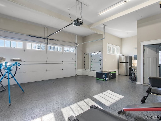 garage featuring stainless steel refrigerator and a garage door opener