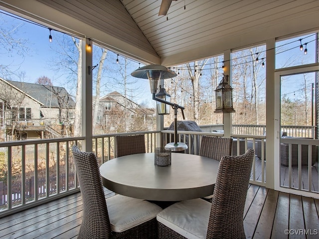 sunroom with lofted ceiling, ceiling fan, a healthy amount of sunlight, and wood ceiling