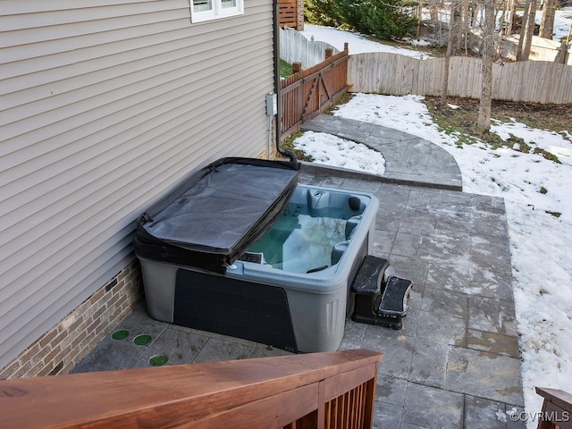 snow covered patio with a hot tub