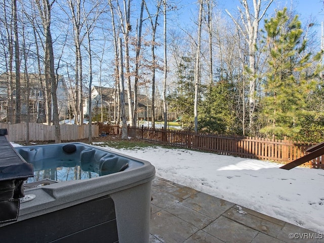 snow covered patio featuring a hot tub