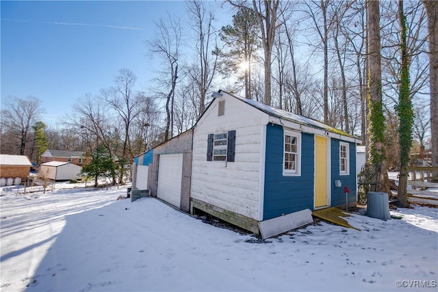 snow covered structure with a garage