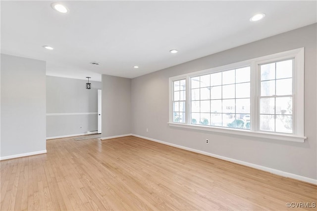 spare room with a baseboard radiator and light hardwood / wood-style flooring