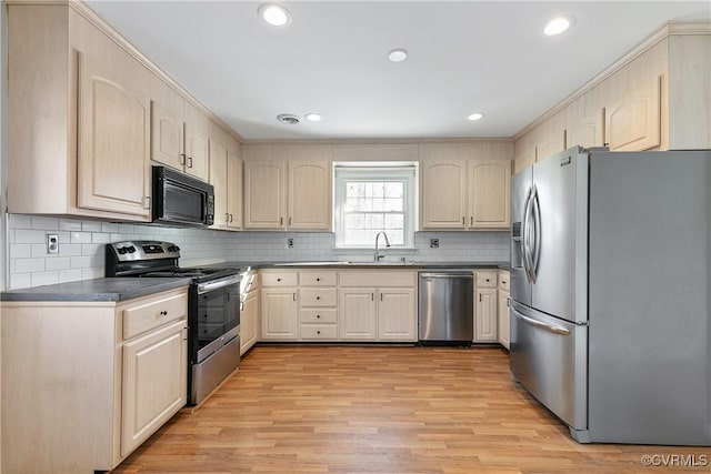 kitchen with stainless steel appliances, decorative backsplash, light brown cabinets, and sink