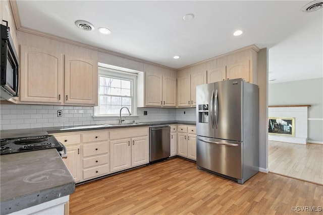 kitchen with stainless steel appliances, light brown cabinetry, light hardwood / wood-style floors, and sink