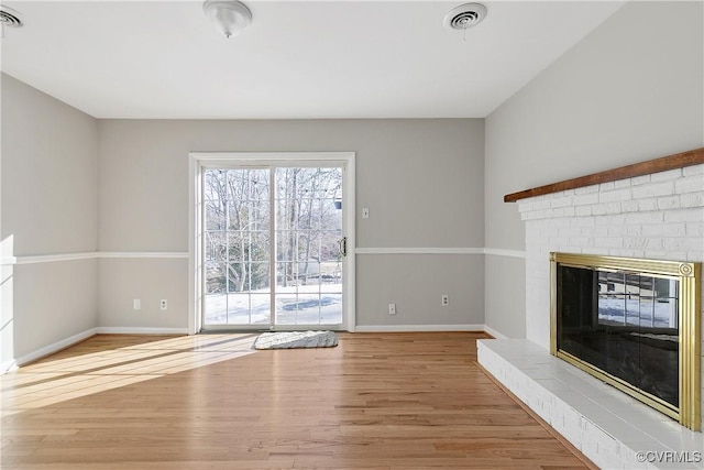 unfurnished living room with wood-type flooring and a fireplace