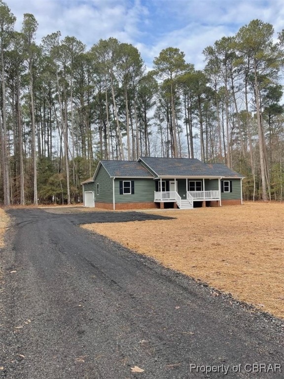 ranch-style home with a porch and a garage