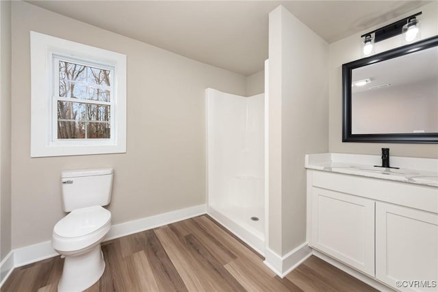 bathroom featuring a shower, vanity, hardwood / wood-style flooring, and toilet