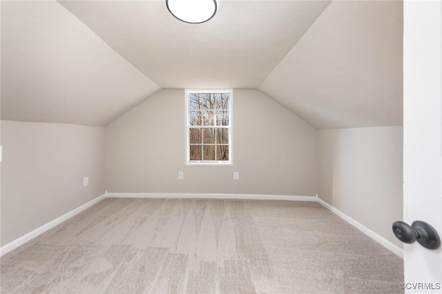 additional living space featuring light carpet and vaulted ceiling