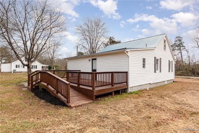 back of house with a deck and a lawn