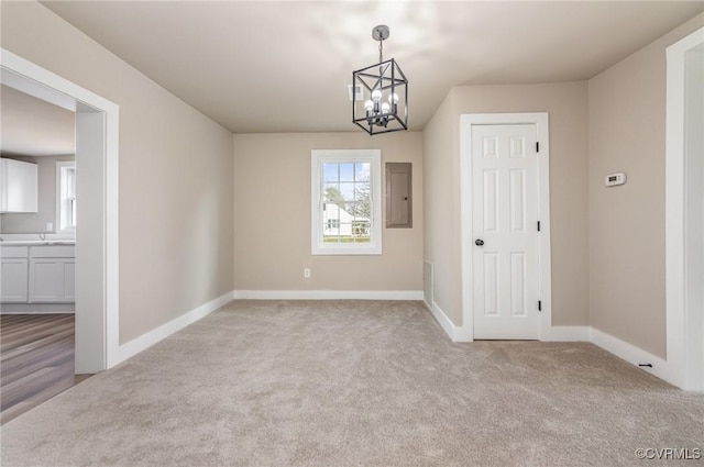 carpeted empty room with electric panel and an inviting chandelier