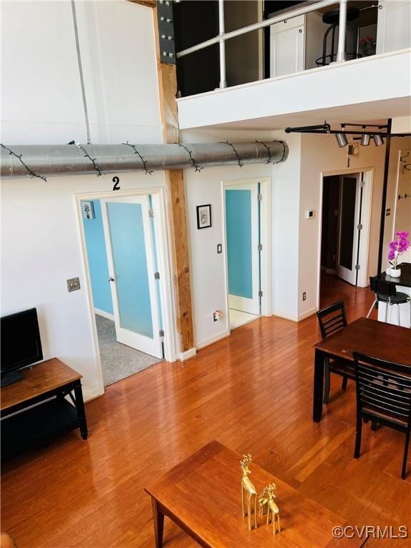 living room with hardwood / wood-style flooring and a towering ceiling