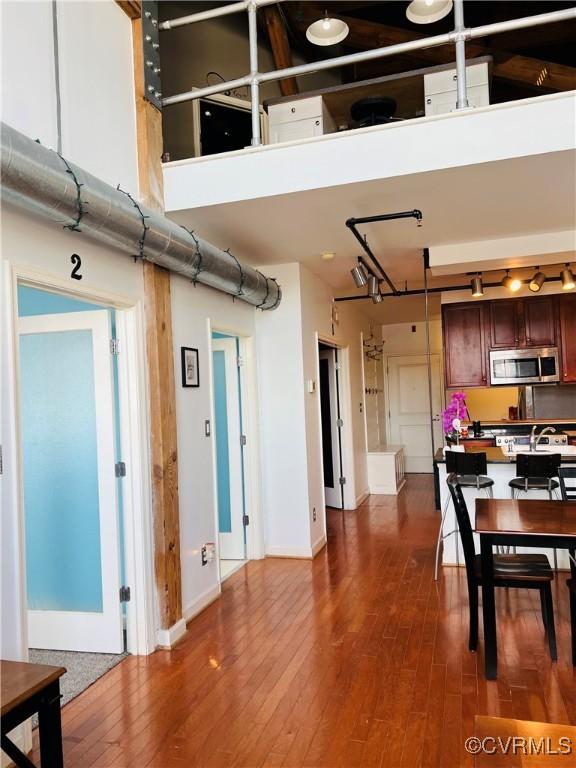 interior space with dark hardwood / wood-style floors and a towering ceiling