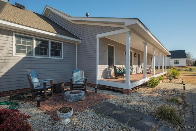 back of house featuring covered porch and a fire pit