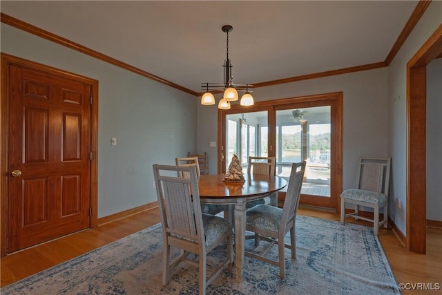 dining room featuring light hardwood / wood-style floors, an inviting chandelier, and crown molding