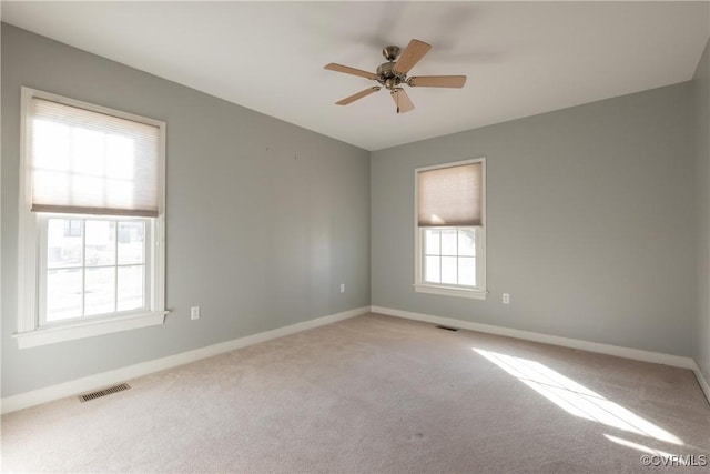 carpeted empty room featuring plenty of natural light and ceiling fan