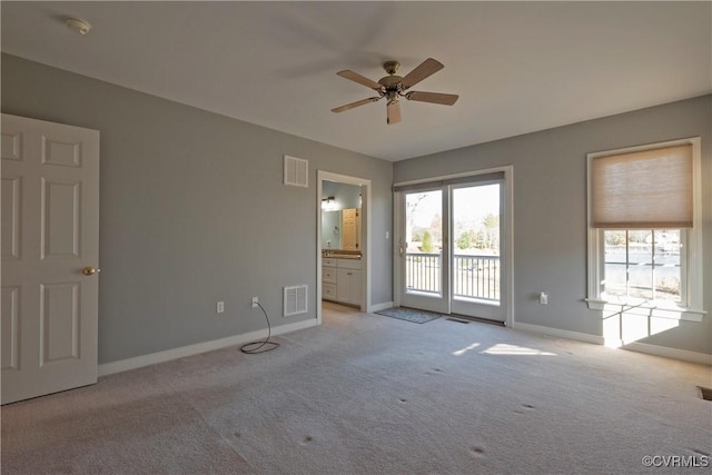 carpeted spare room featuring ceiling fan