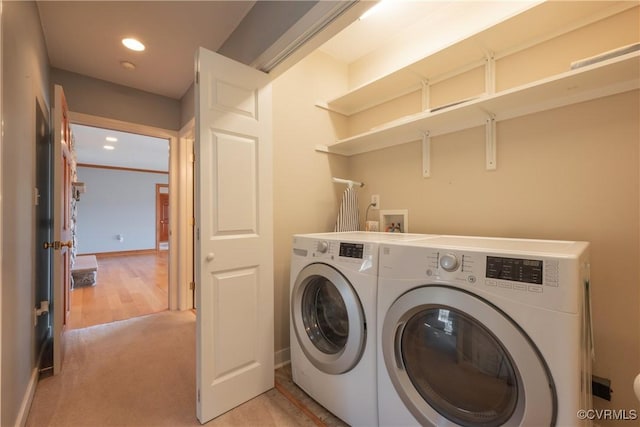 laundry area with washer and clothes dryer and light colored carpet