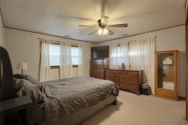 bedroom with ceiling fan, light colored carpet, and crown molding