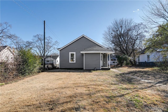 rear view of property featuring a yard