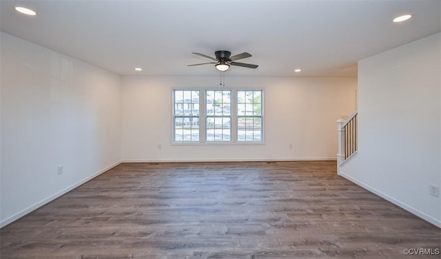 unfurnished living room with ceiling fan and dark wood-type flooring