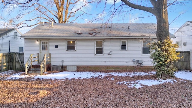 snow covered rear of property featuring cooling unit