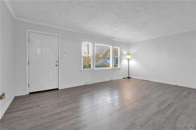 interior space featuring wood-type flooring, ornamental molding, and a textured ceiling