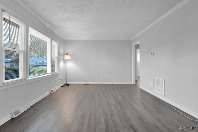 spare room featuring dark wood-type flooring, a textured ceiling, and crown molding