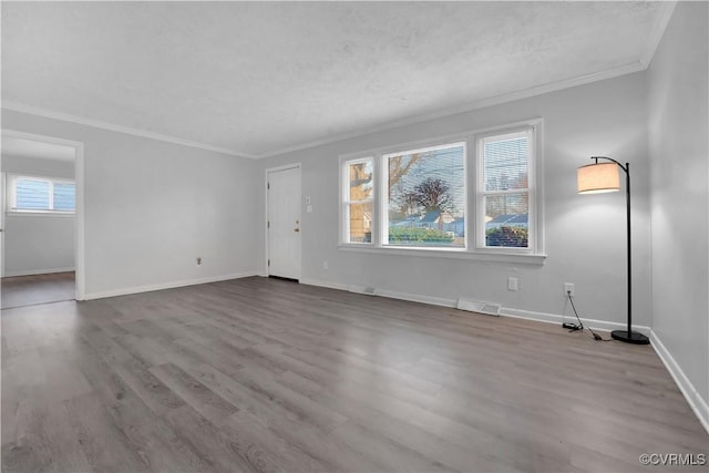 empty room featuring light wood-type flooring, ornamental molding, and a textured ceiling