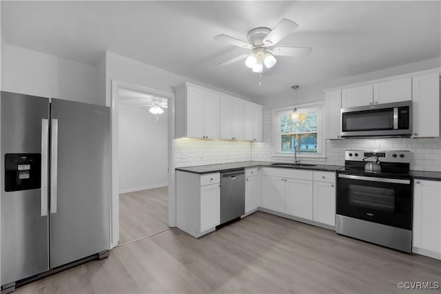 kitchen featuring white cabinetry, light hardwood / wood-style floors, ceiling fan, appliances with stainless steel finishes, and sink