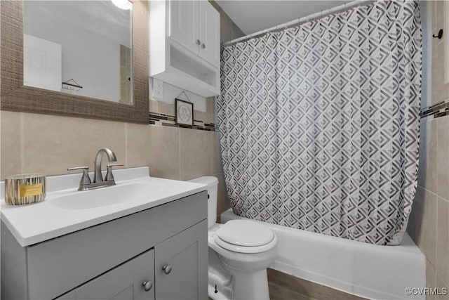 bathroom featuring tile walls, toilet, and vanity