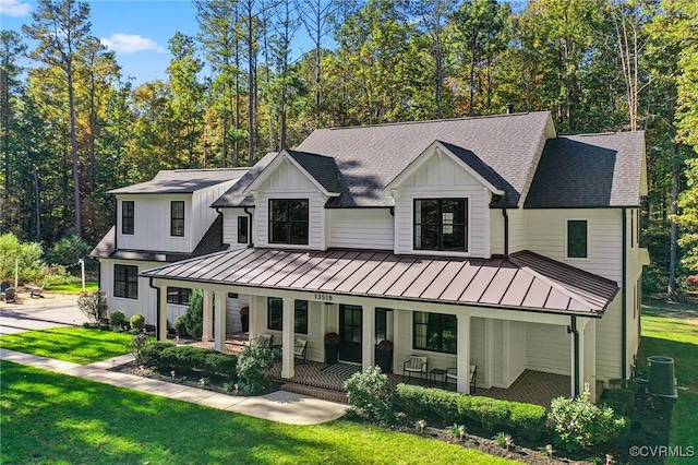 back of property with a yard, cooling unit, and a porch