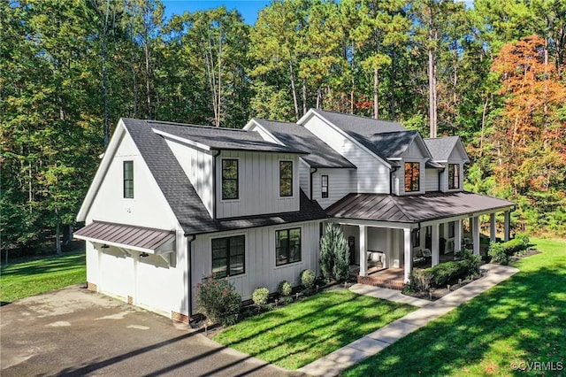 modern farmhouse with covered porch and a front yard