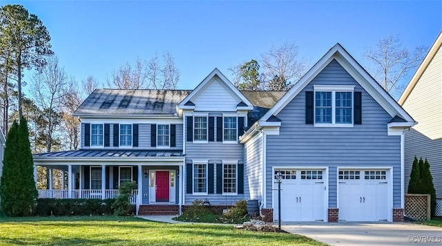 view of front of home with covered porch, a garage, and a front yard