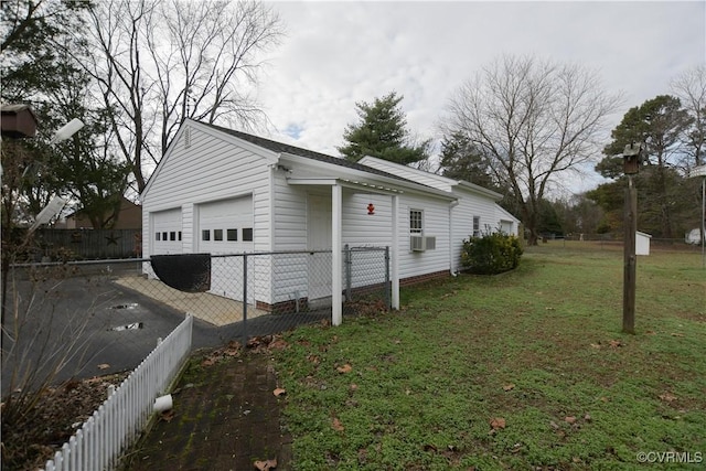 view of side of property featuring a lawn, cooling unit, and a garage