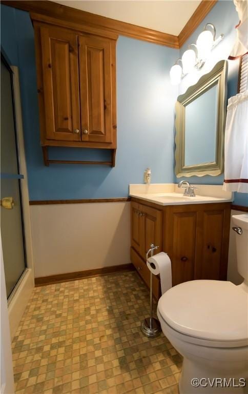 bathroom featuring an enclosed shower, vanity, toilet, and ornamental molding