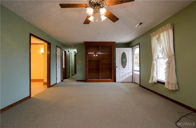 interior space with a textured ceiling and ceiling fan