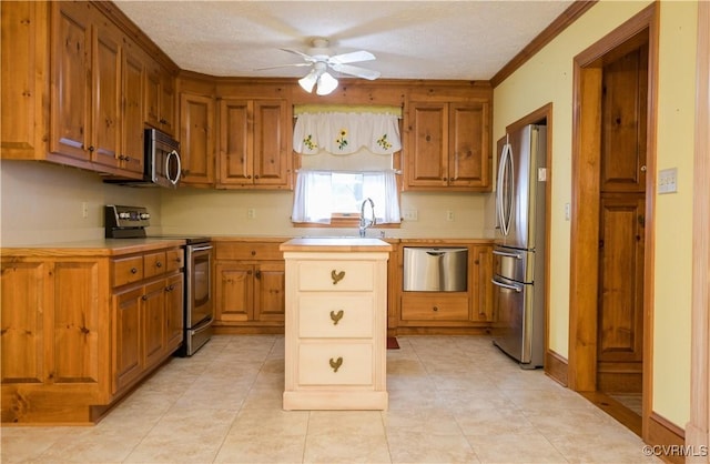 kitchen featuring appliances with stainless steel finishes, a textured ceiling, ceiling fan, and ornamental molding