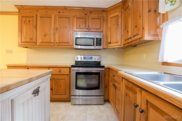 kitchen featuring appliances with stainless steel finishes and light tile patterned flooring