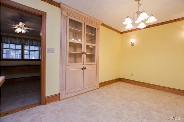 tiled spare room featuring ceiling fan with notable chandelier and crown molding