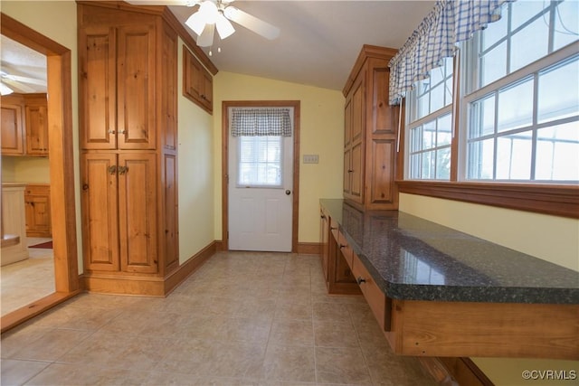 interior space with ceiling fan, plenty of natural light, light tile patterned floors, and lofted ceiling