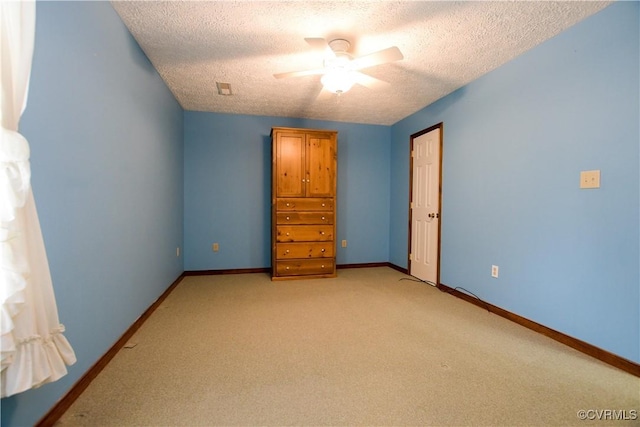 unfurnished bedroom featuring a textured ceiling, ceiling fan, and light carpet